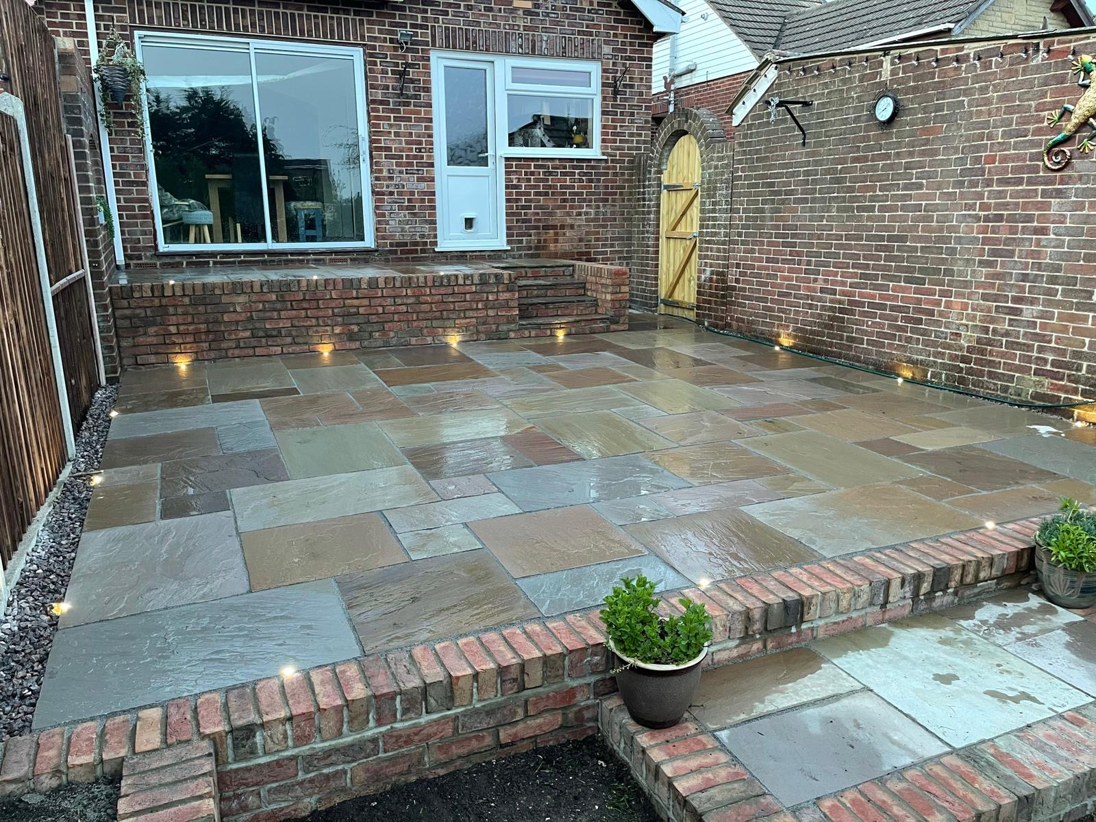 Natural stone patio with raised brickwork and garden lights
