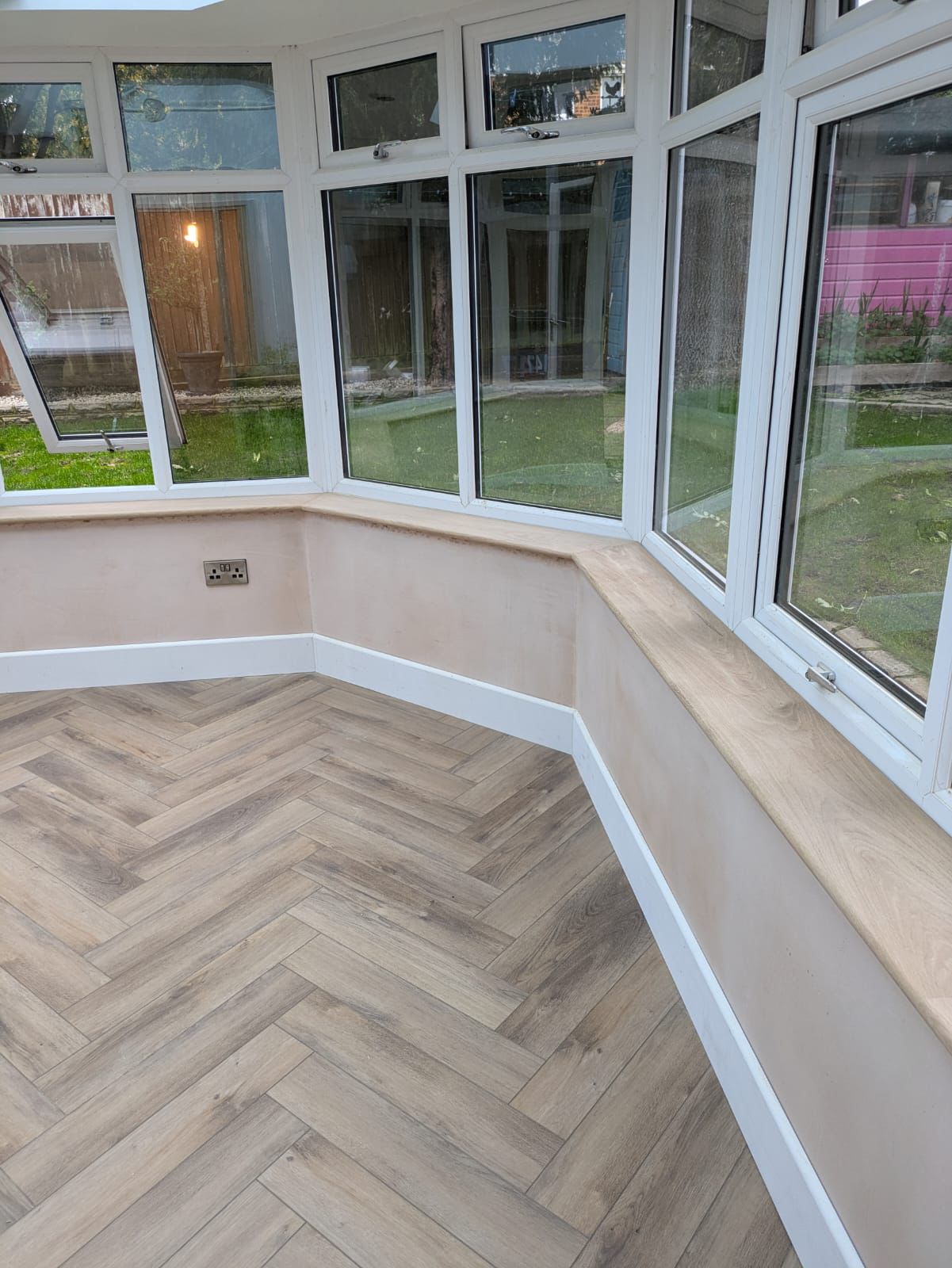 Conservatory interior with herringbone flooring and window boards